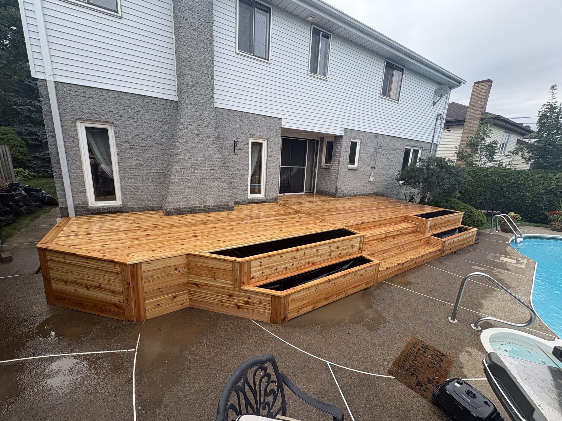 Poolside wood deck with wide central steps and built in planters