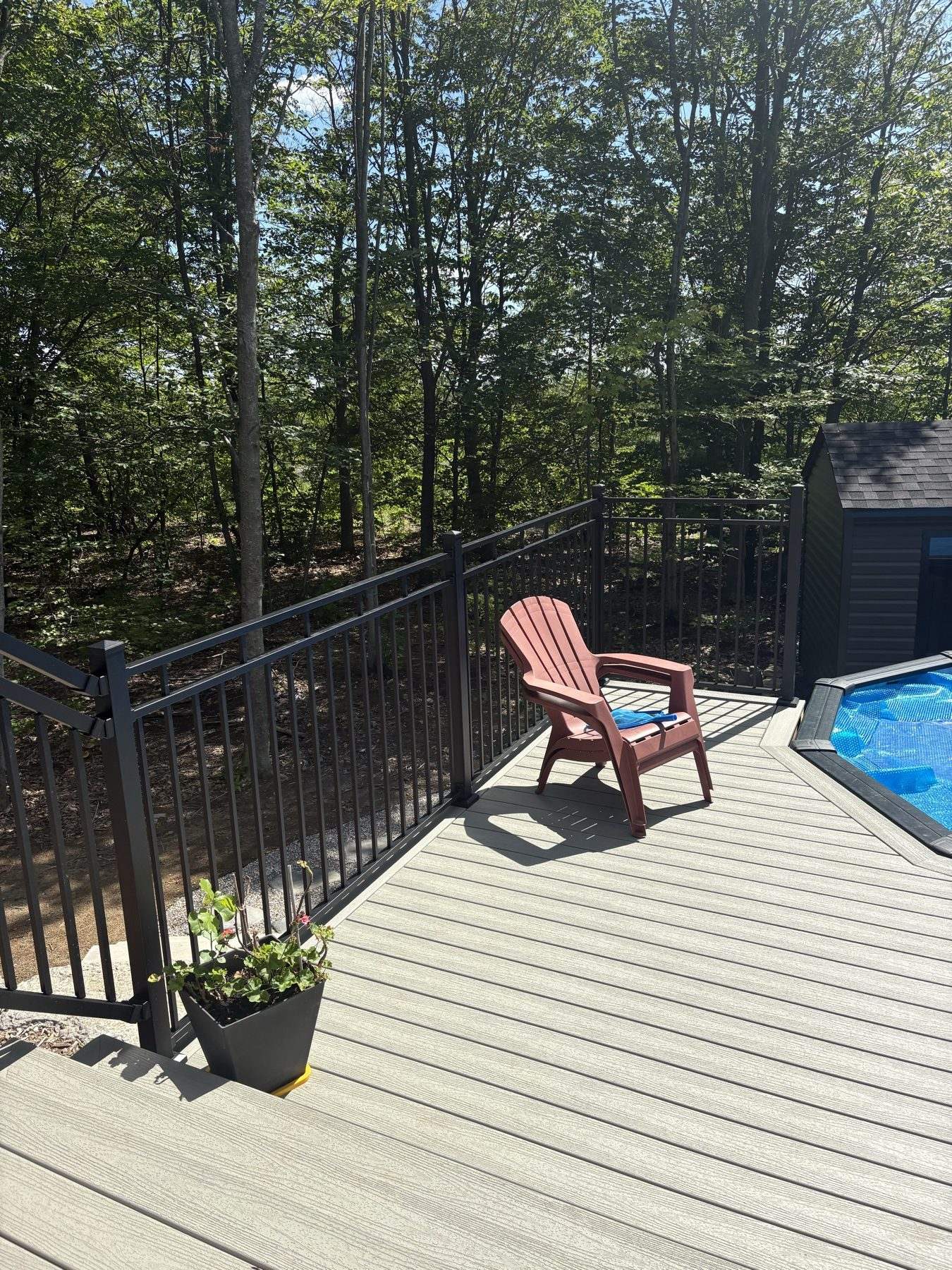 Grey composite pool deck with black aluminum railing