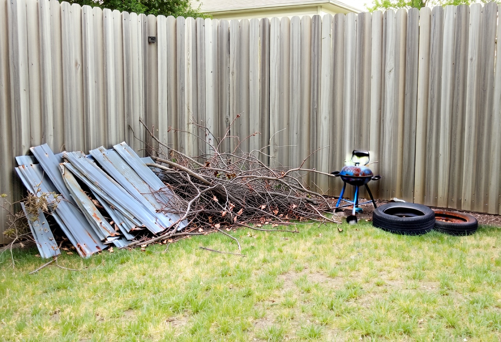 Backyard corner with old fence panels and debris